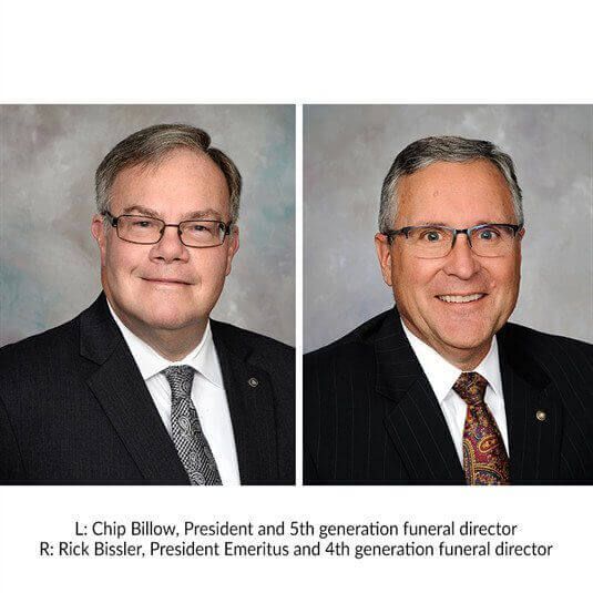 Two men in suits and ties are standing next to each other