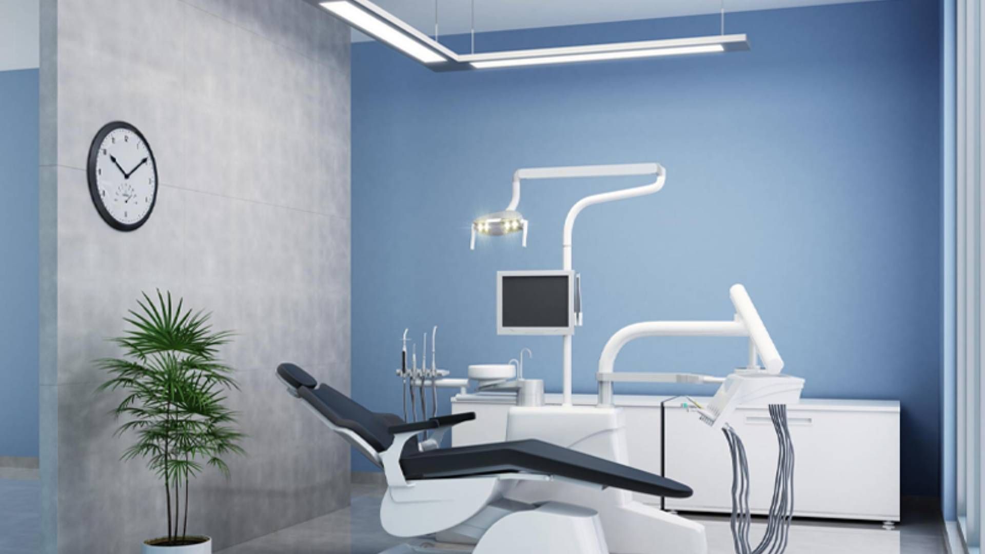 A modern dental exam room with a black reclining chair, dental equipment, a desk, a potted plant, and a wall clock.