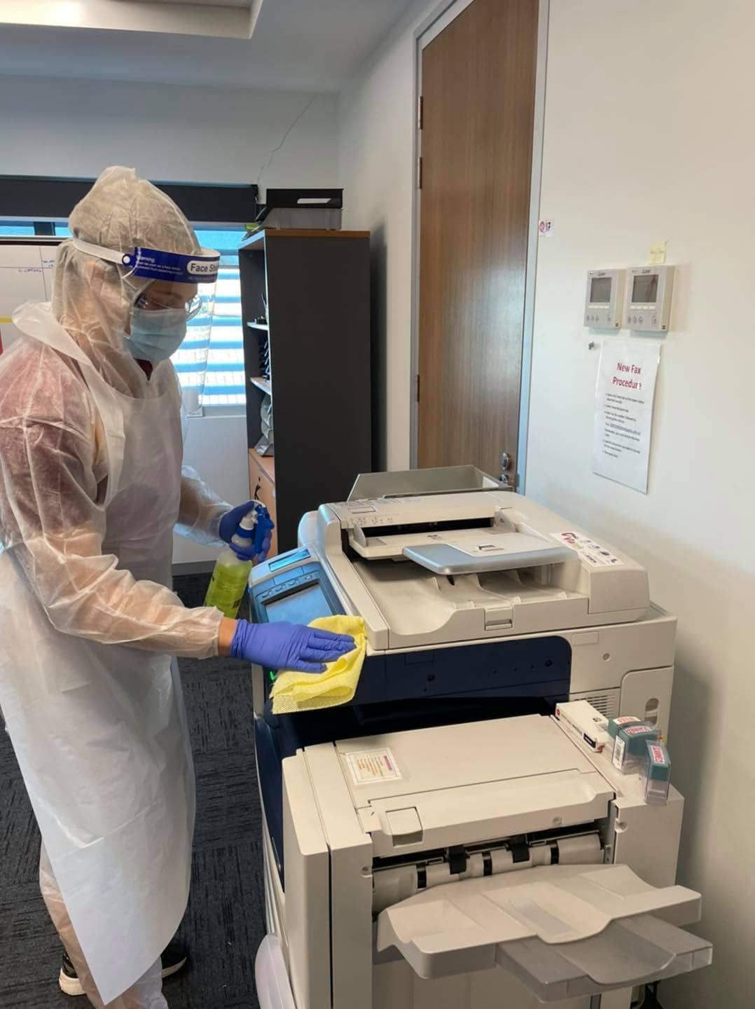 Someone Cleaning a Photocopier Machine with Cloth — Carpet Cleaners in Tatura, VIC