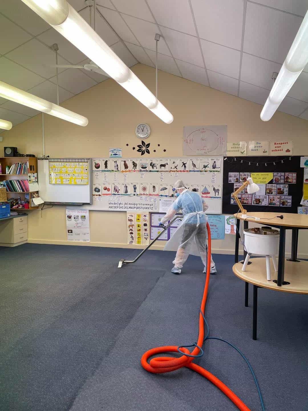 Someone Cleaning the Classroom Floor with Cleaner — Carpet Cleaners in Tatura, VIC