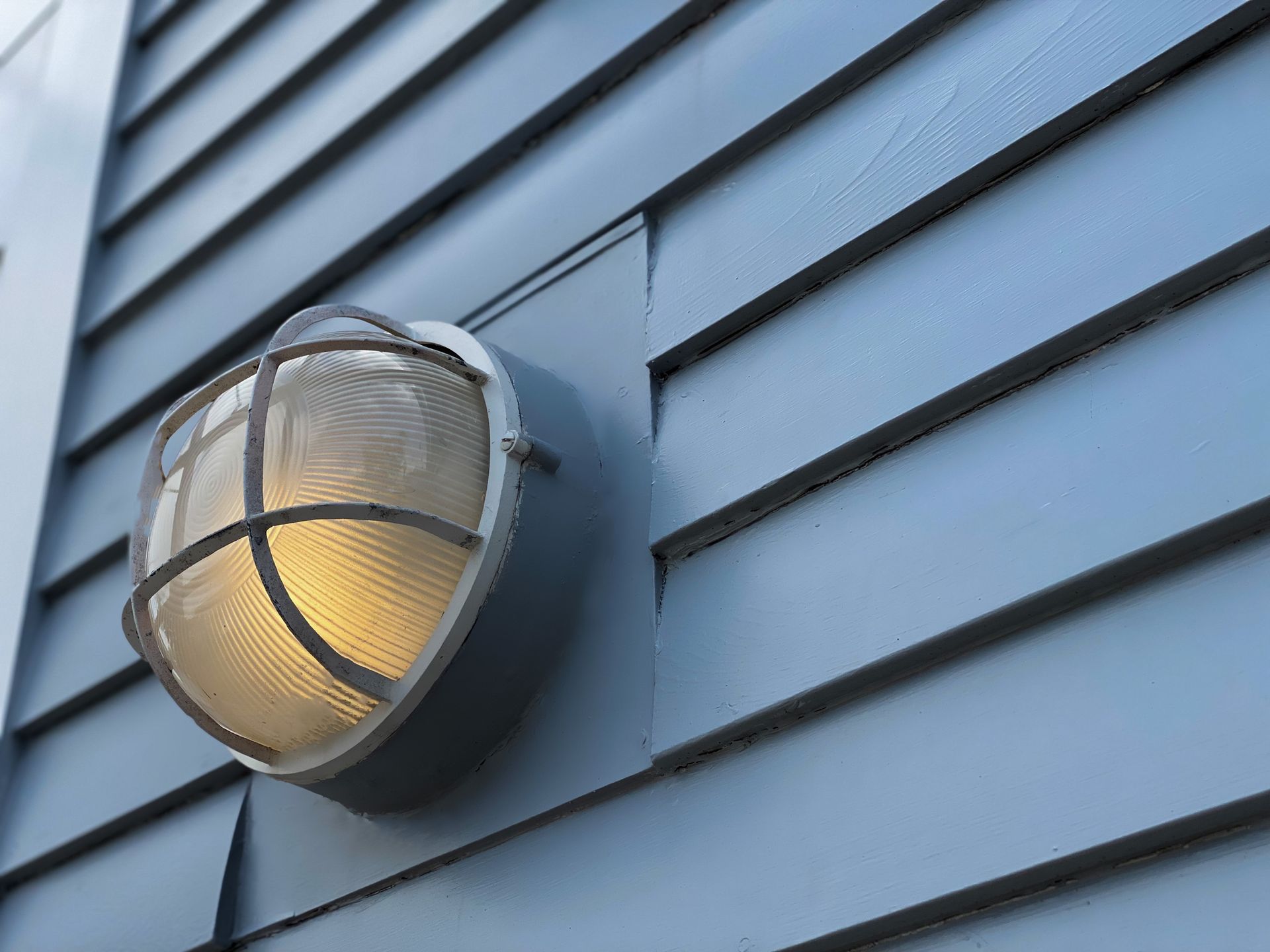 A light on the side of a blue building