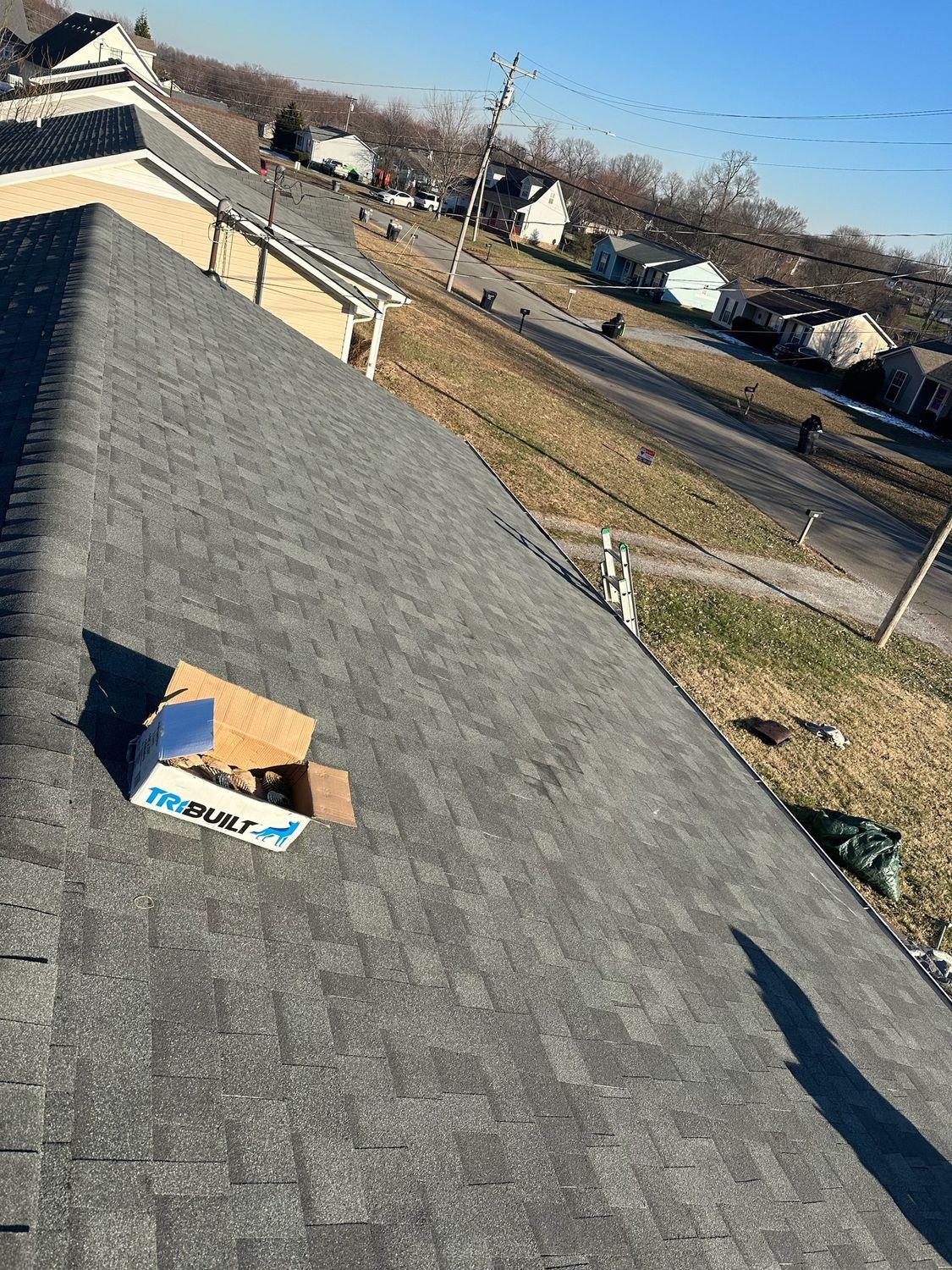 A box is sitting on the roof of a house.