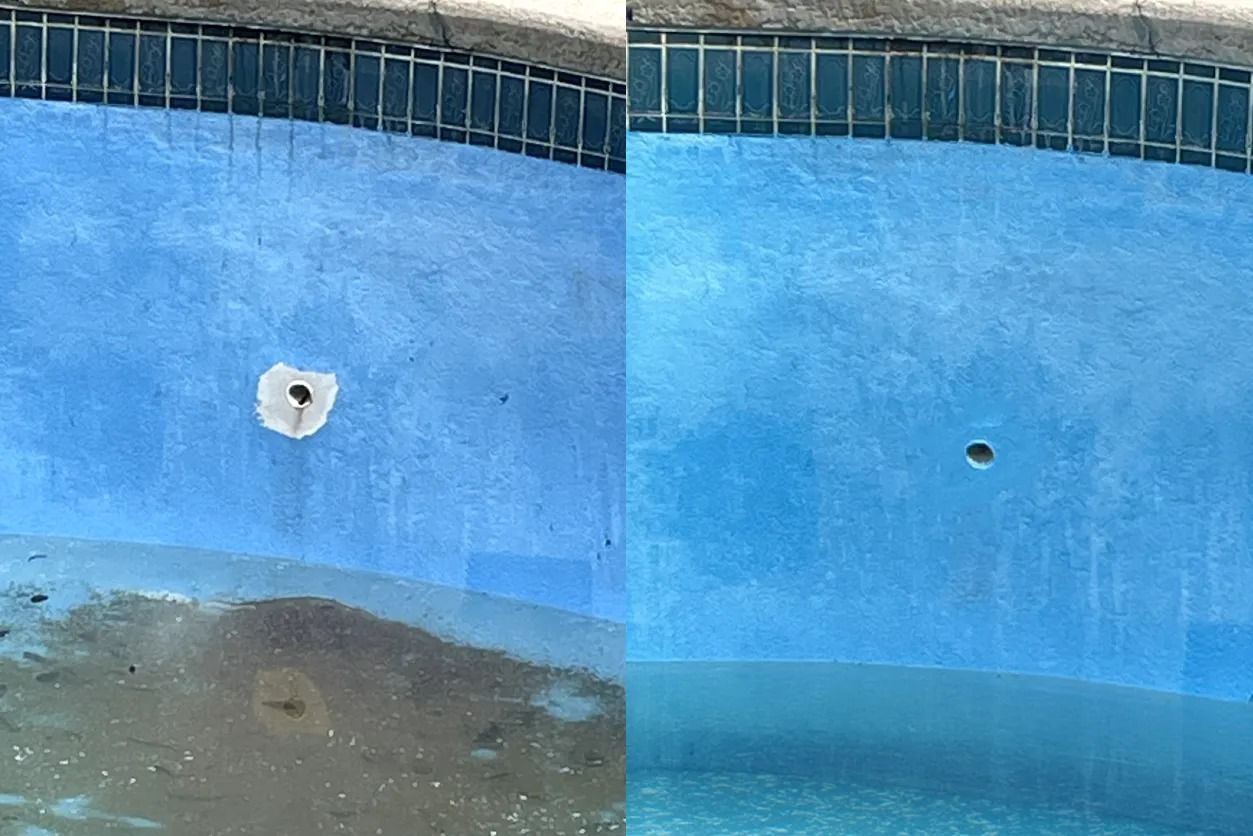 Empty blue swimming pool with a dirty patch and two wall drains.
