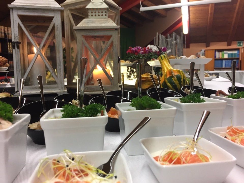 Un tavolo da buffet con ciotole di cibo e cucchiai sopra