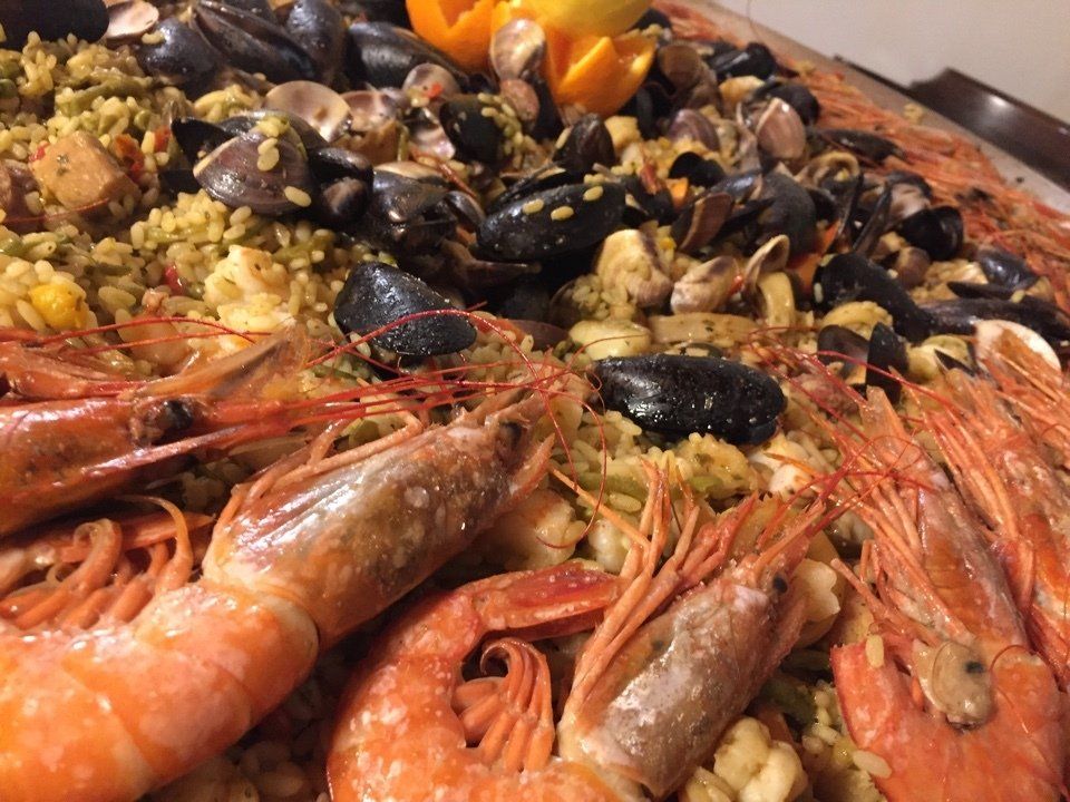 Un primo piano di un piatto di cibo con gamberi, cozze e riso.