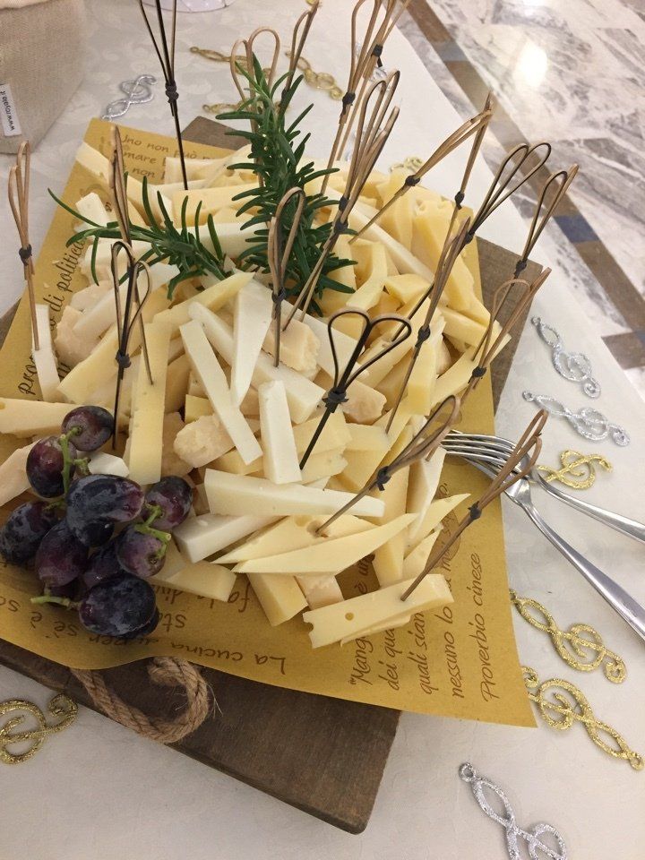 Un vassoio di formaggio con stuzzicadenti e uva su un tavolo