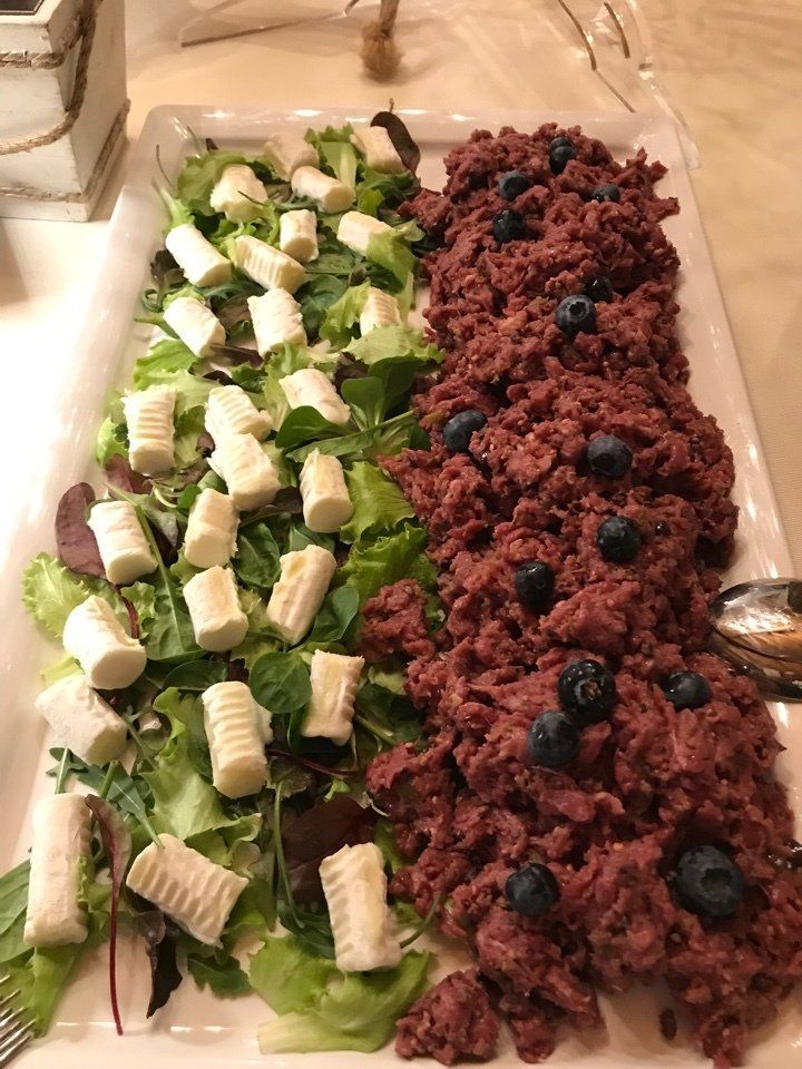 Un piatto di cibo con insalata e carne su un tavolo.