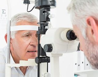Optometrist doing sight testing for senior patient - vision testing in Medford, OR