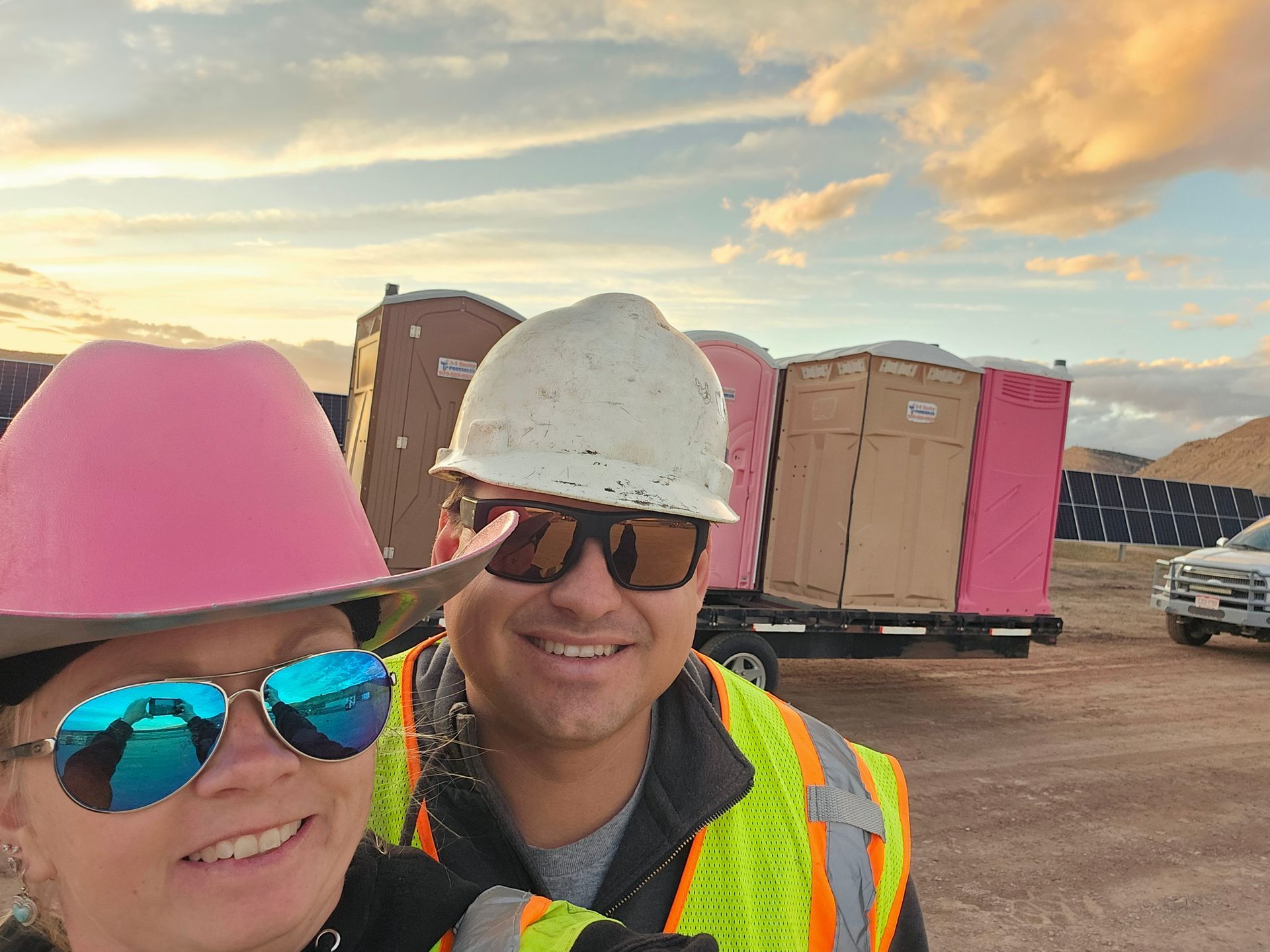 Two blue portable toilets are sitting next to each other on the side of the road.