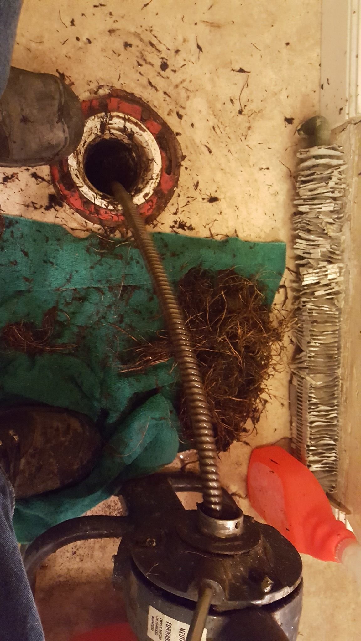 A hose is sticking out of a hole in a sink.
