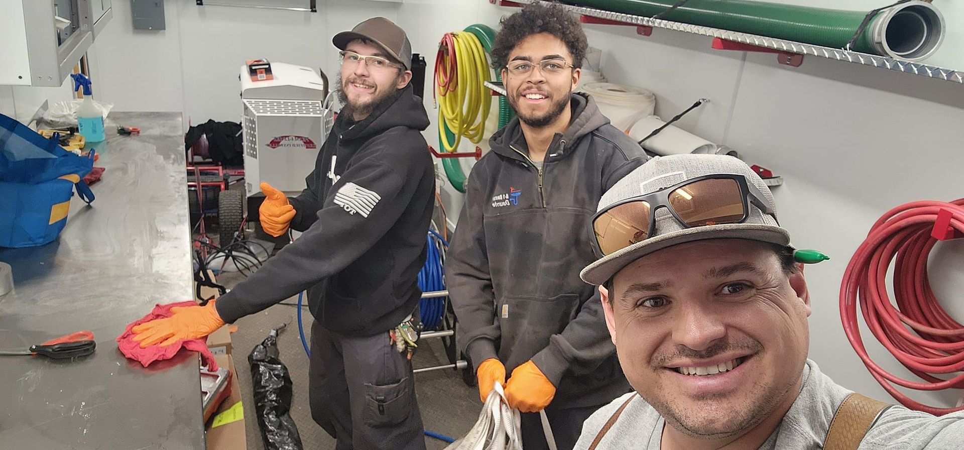 Three men are standing next to each other in a room.