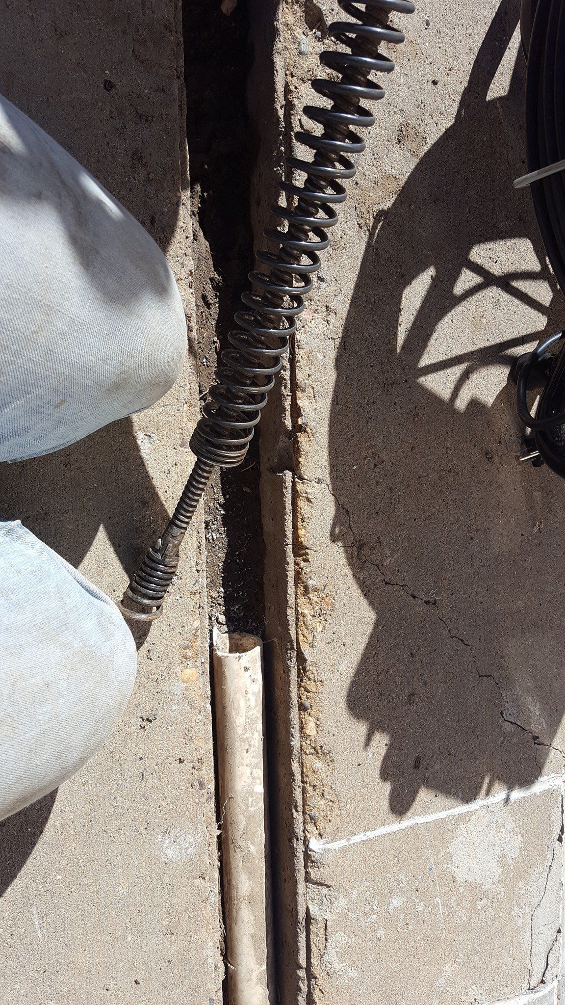 A person is standing next to a pipe on the ground.