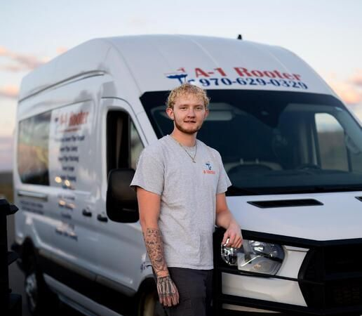 A young man with curly hair and a beard is looking at the camera.