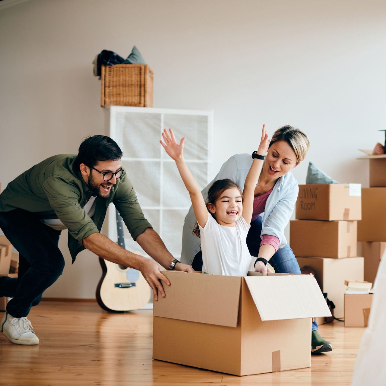 a family is playing in a living room surrounded by moving boxes