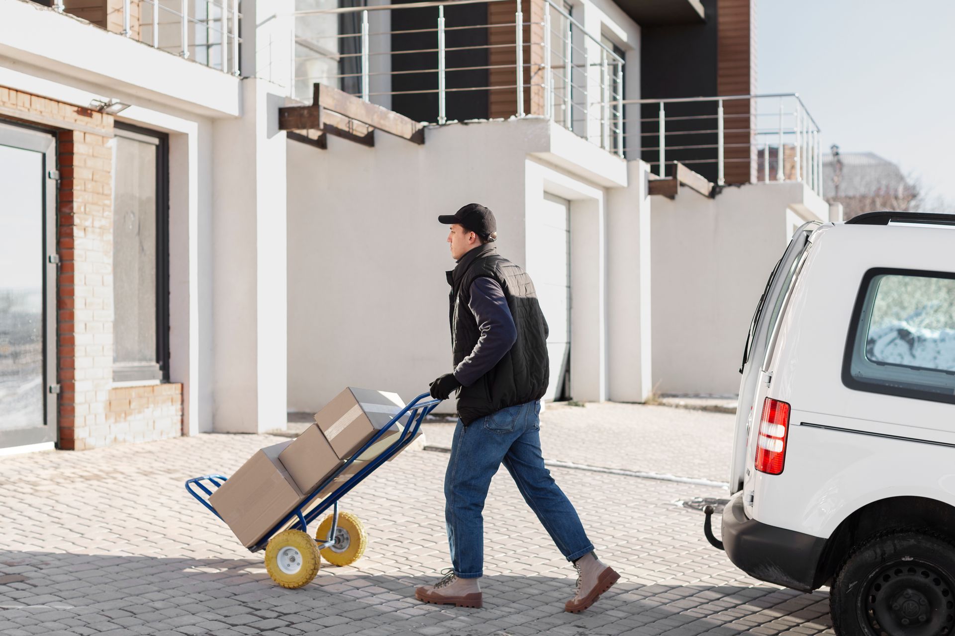 a delivery man is pushing a cart full of boxes