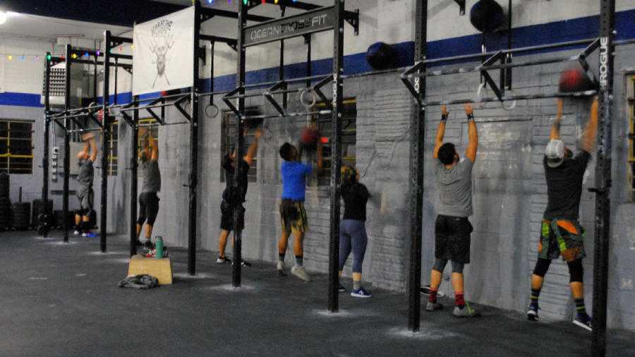 a group of people are doing pull ups in front of a sign that says legend in the pit
