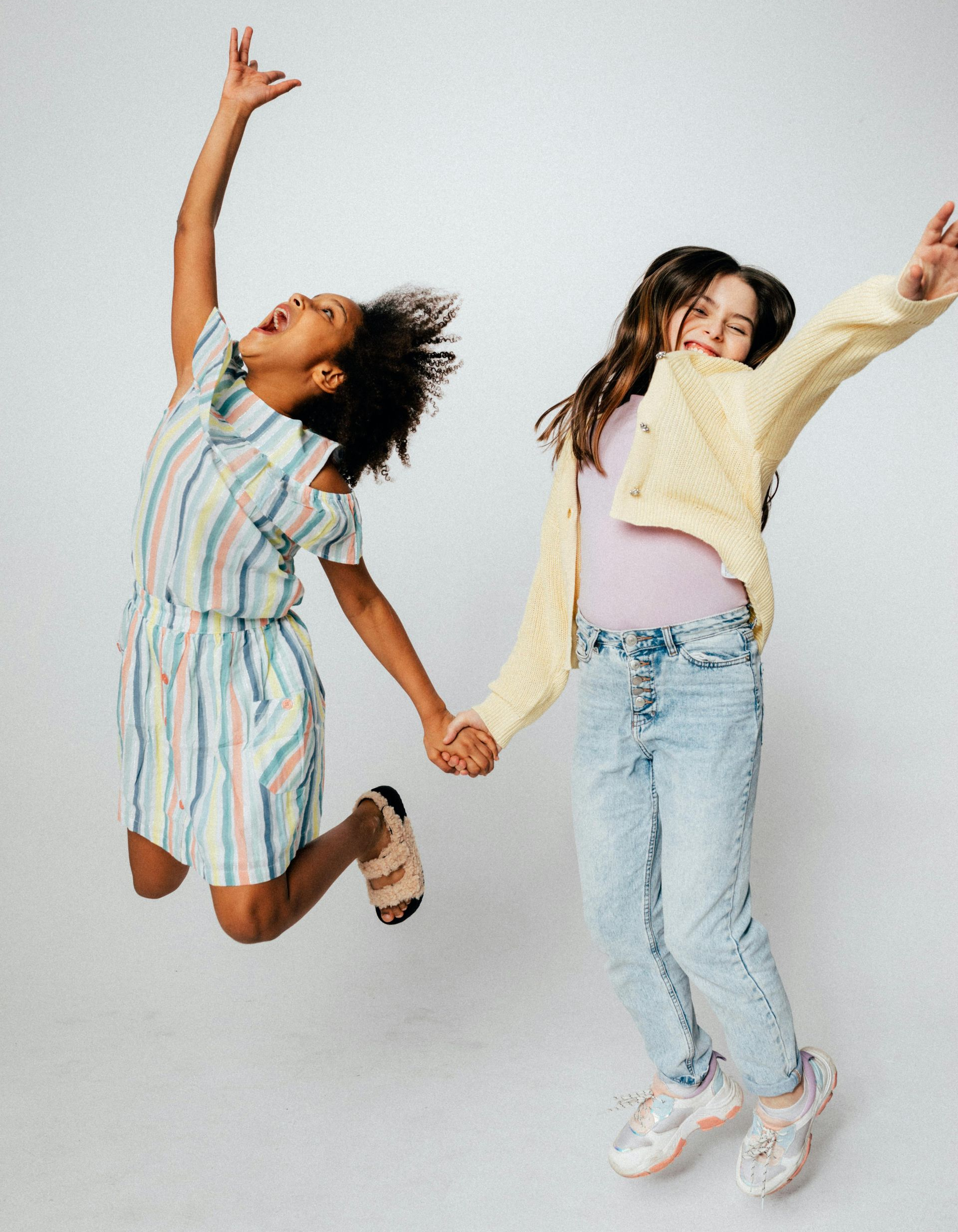 A woman is dancing in front of a glass building while holding an umbrella.