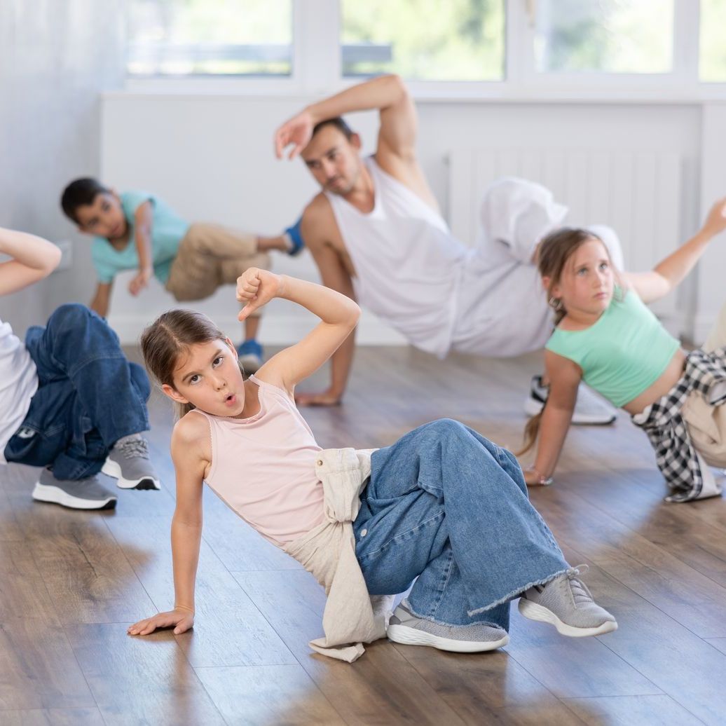 A group of children are dancing in a dance studio.