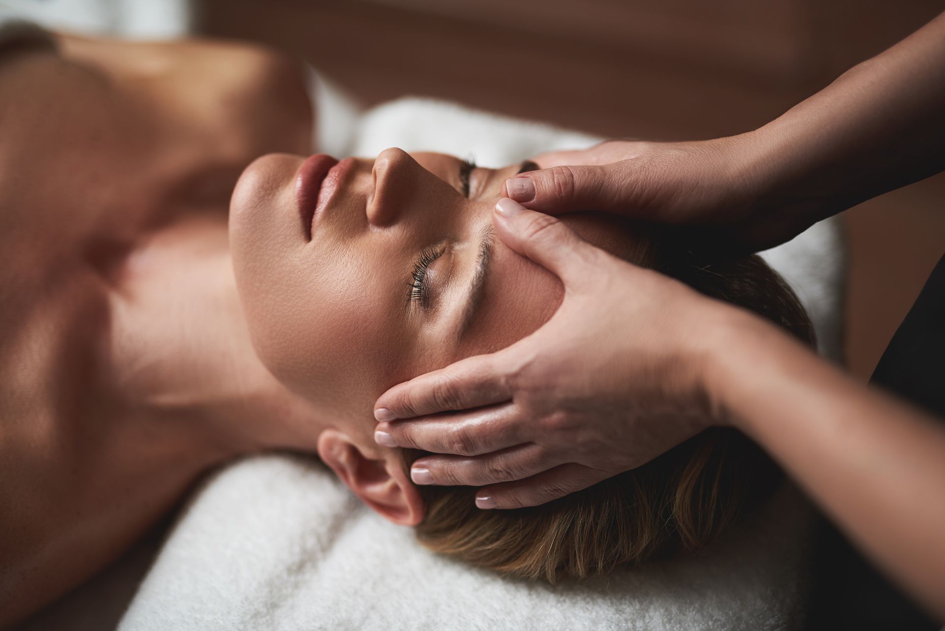 A woman is getting a head massage at a spa.