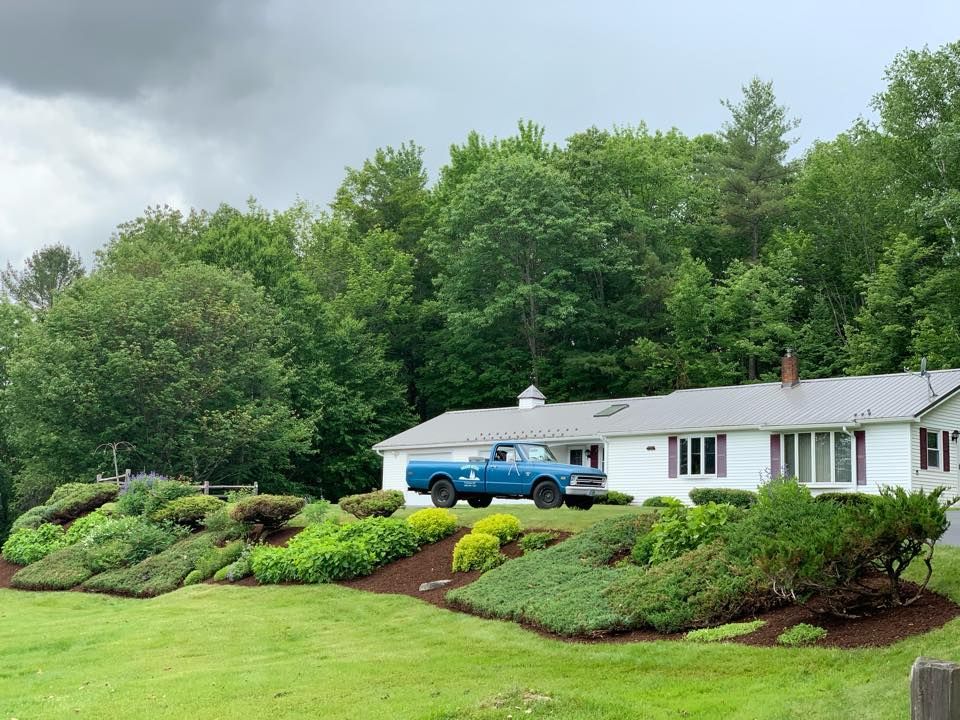 A blue truck is parked in front of a house