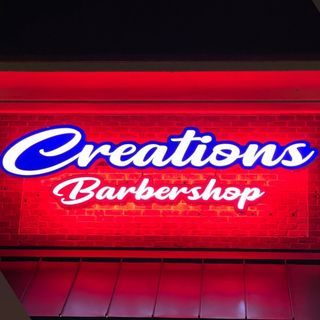 A red sign that says creations barbershop on it
