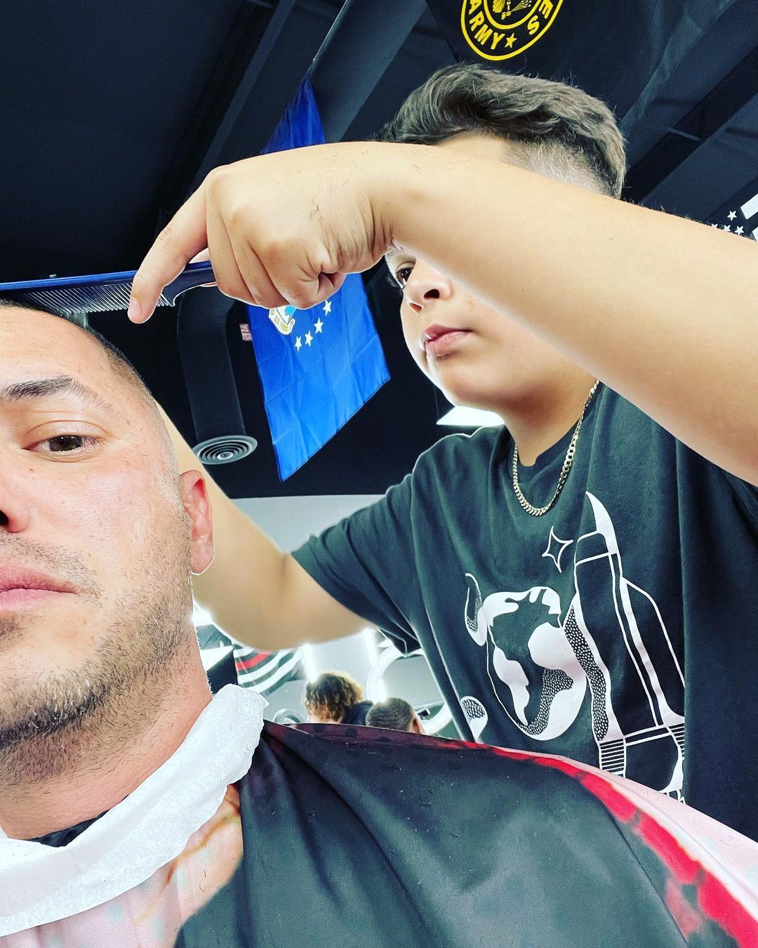 A man is getting his hair cut at a barber shop