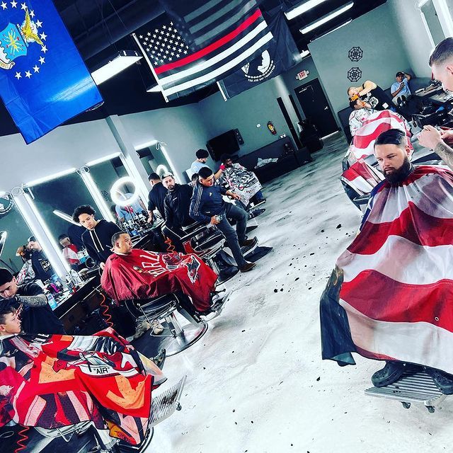 A group of men are getting their hair cut at a barber shop
