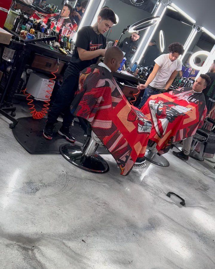 A man is getting his hair cut at a barber shop.