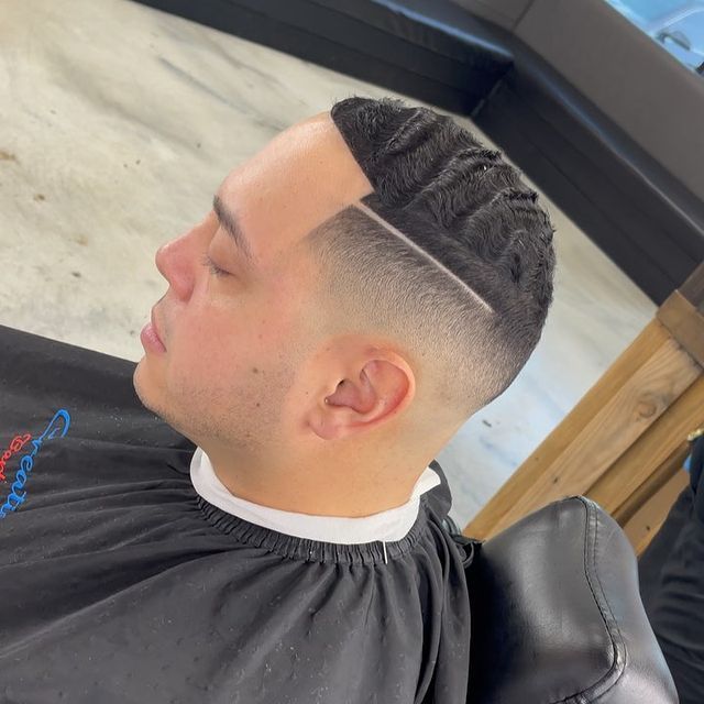 A man is getting his hair cut at a barber shop