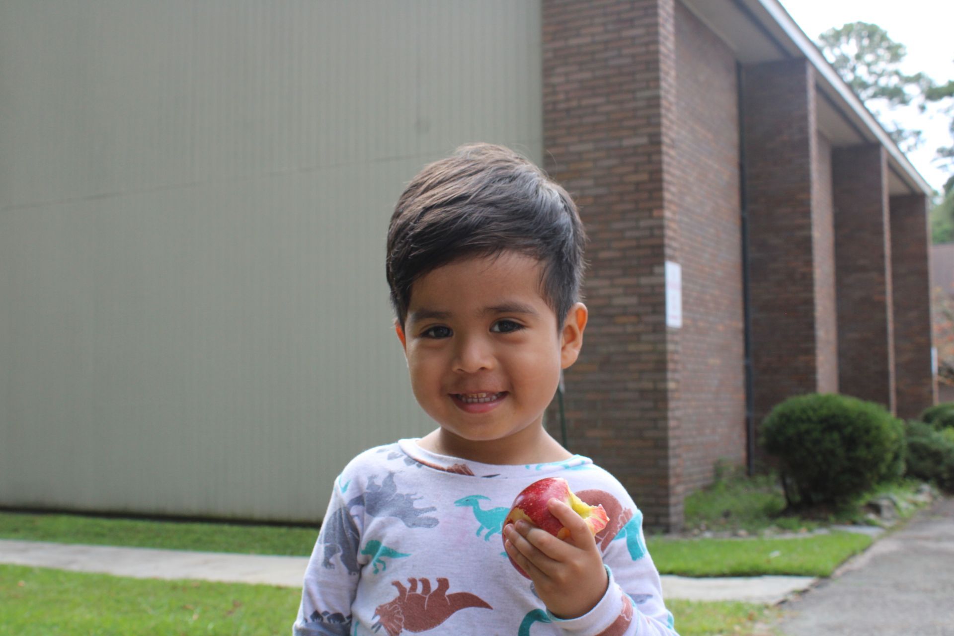 A young boy enjoying an apple during an LCD event.