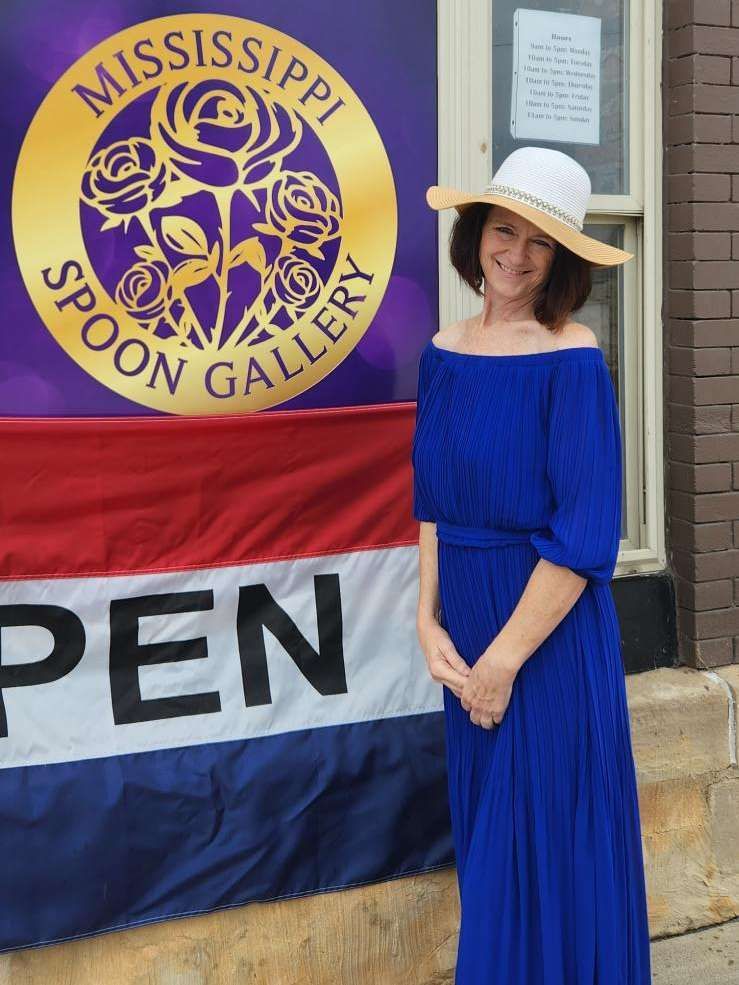 Woman in blue dress and hat.