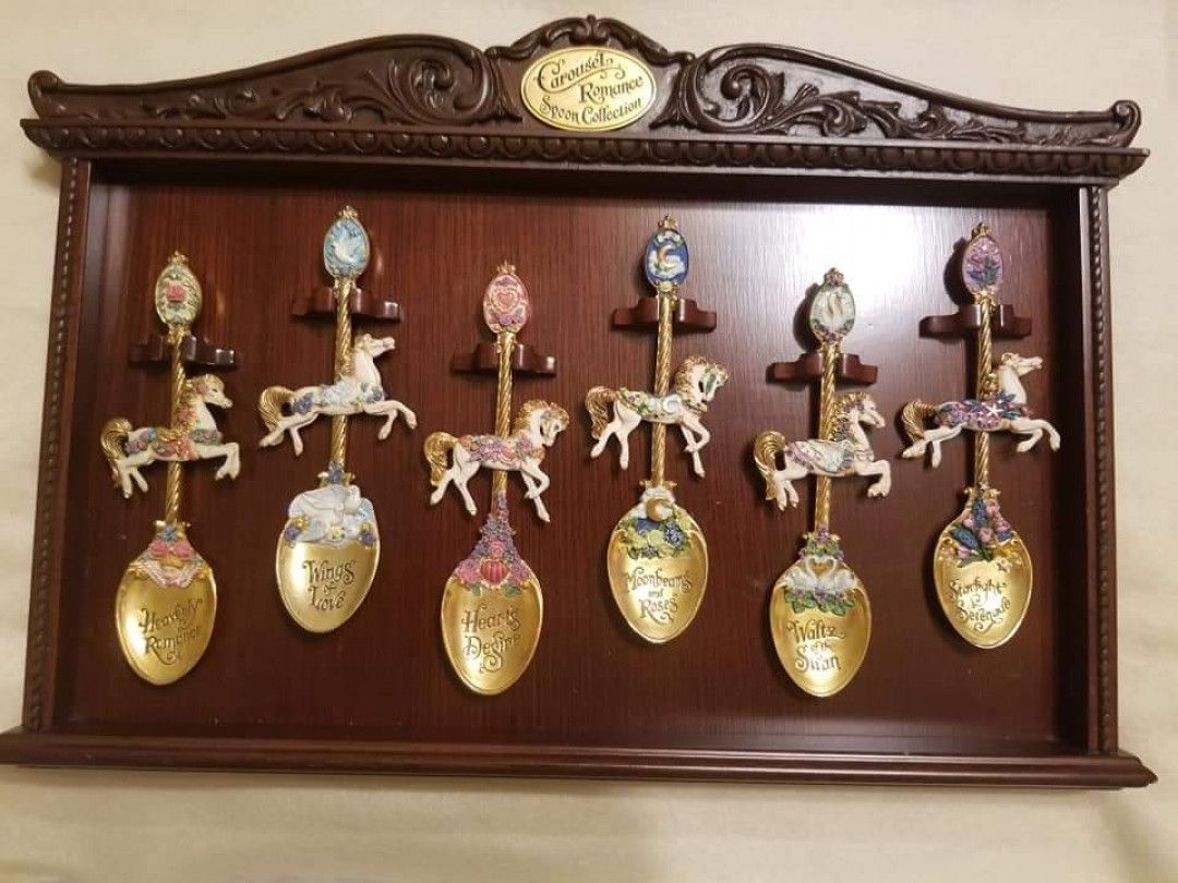 Wooden display case with carousel-themed decorative spoons.