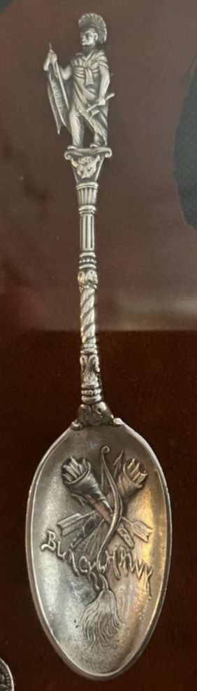 Silver spoon with figure on top.