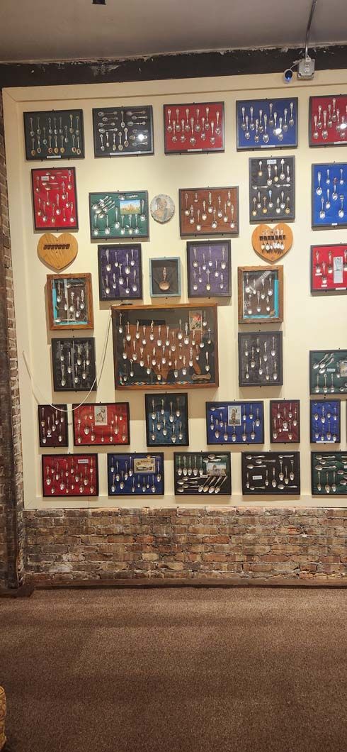 Wall display of framed items, with red, blue, green and brown frames. 
