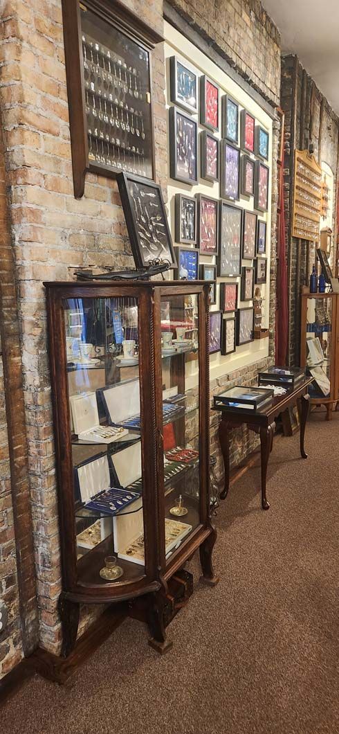 A wooden display cabinet with glass doors in a room with brick walls.