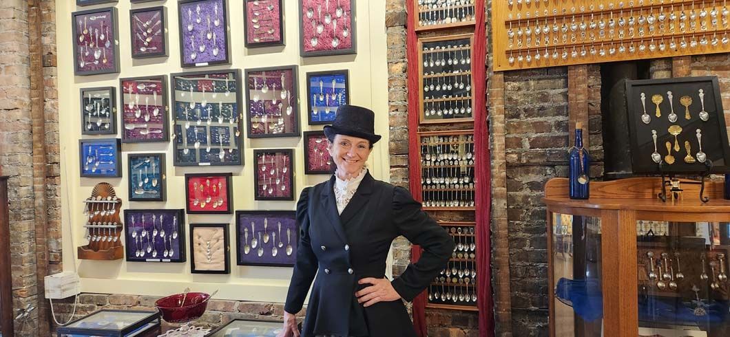 Woman in a dark outfit and bowler hat.
