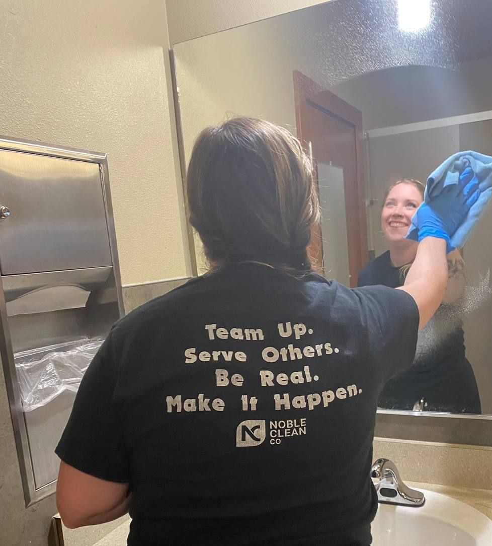 A woman wearing a black shirt that says team up serve others be real make it happen