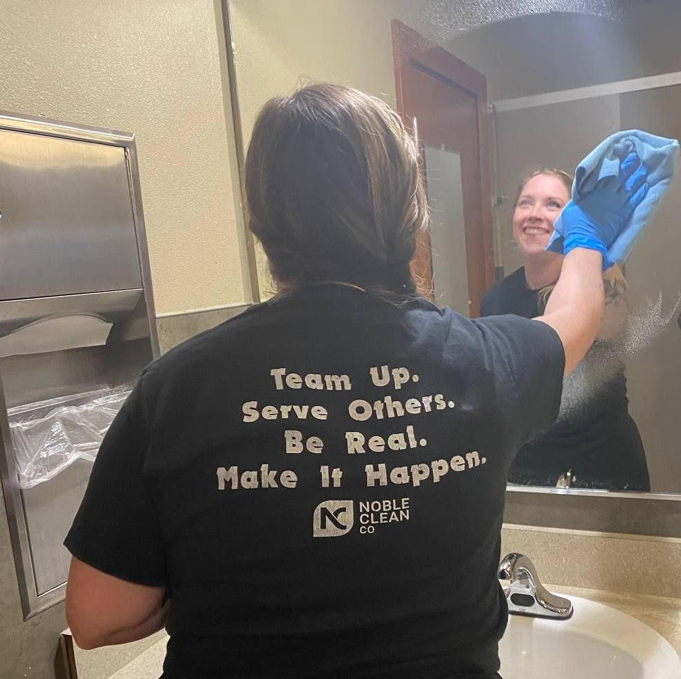 A woman wearing a black shirt that says team up serve others be real make it happen