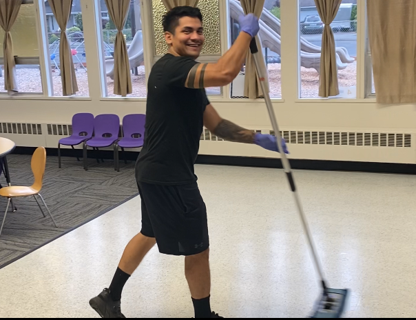 A man wearing blue gloves is mopping the floor