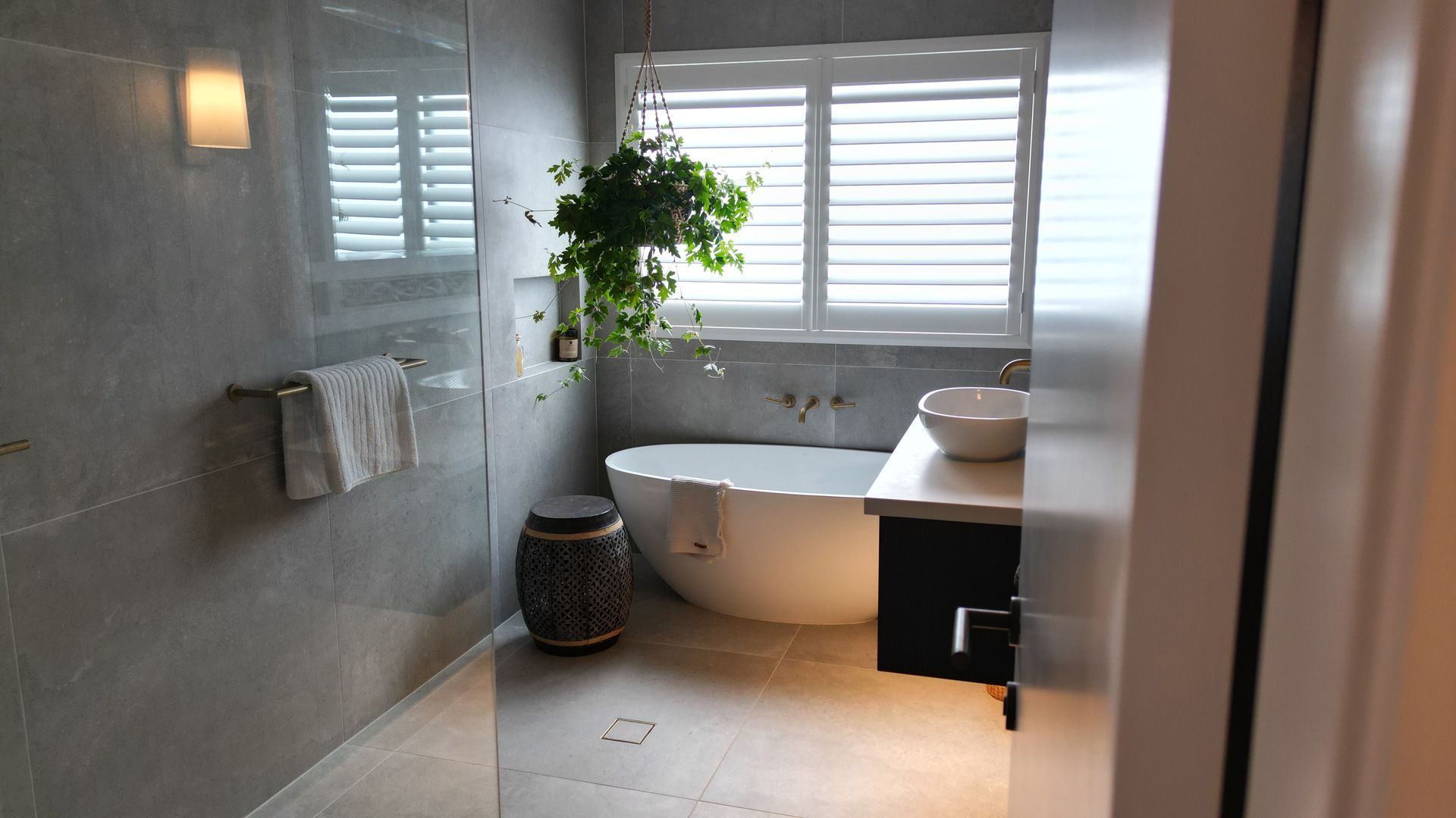 A bathroom with a tub, sink, and window.