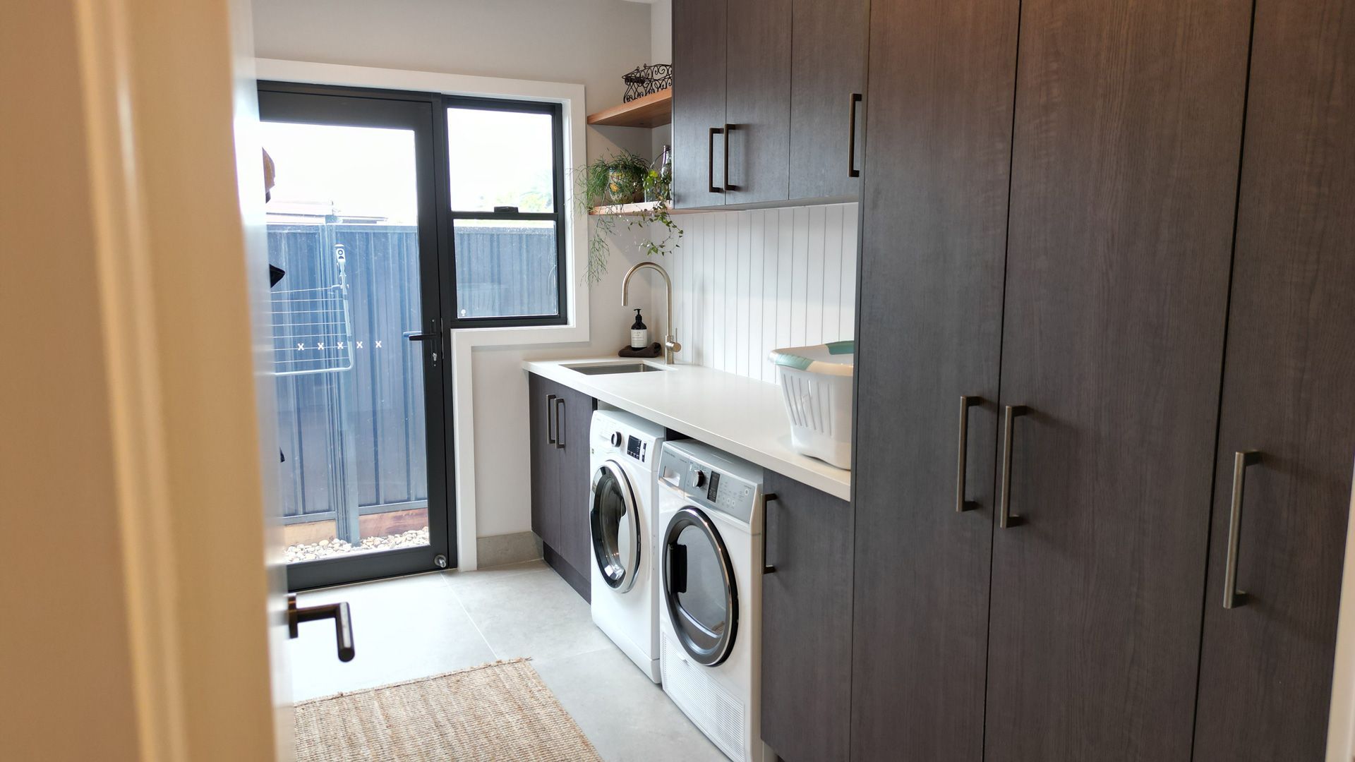 A laundry room with a washer and dryer and a sink.