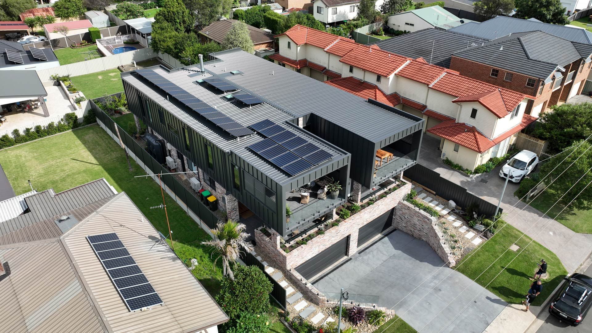 An aerial view of a house with solar panels on the roof.