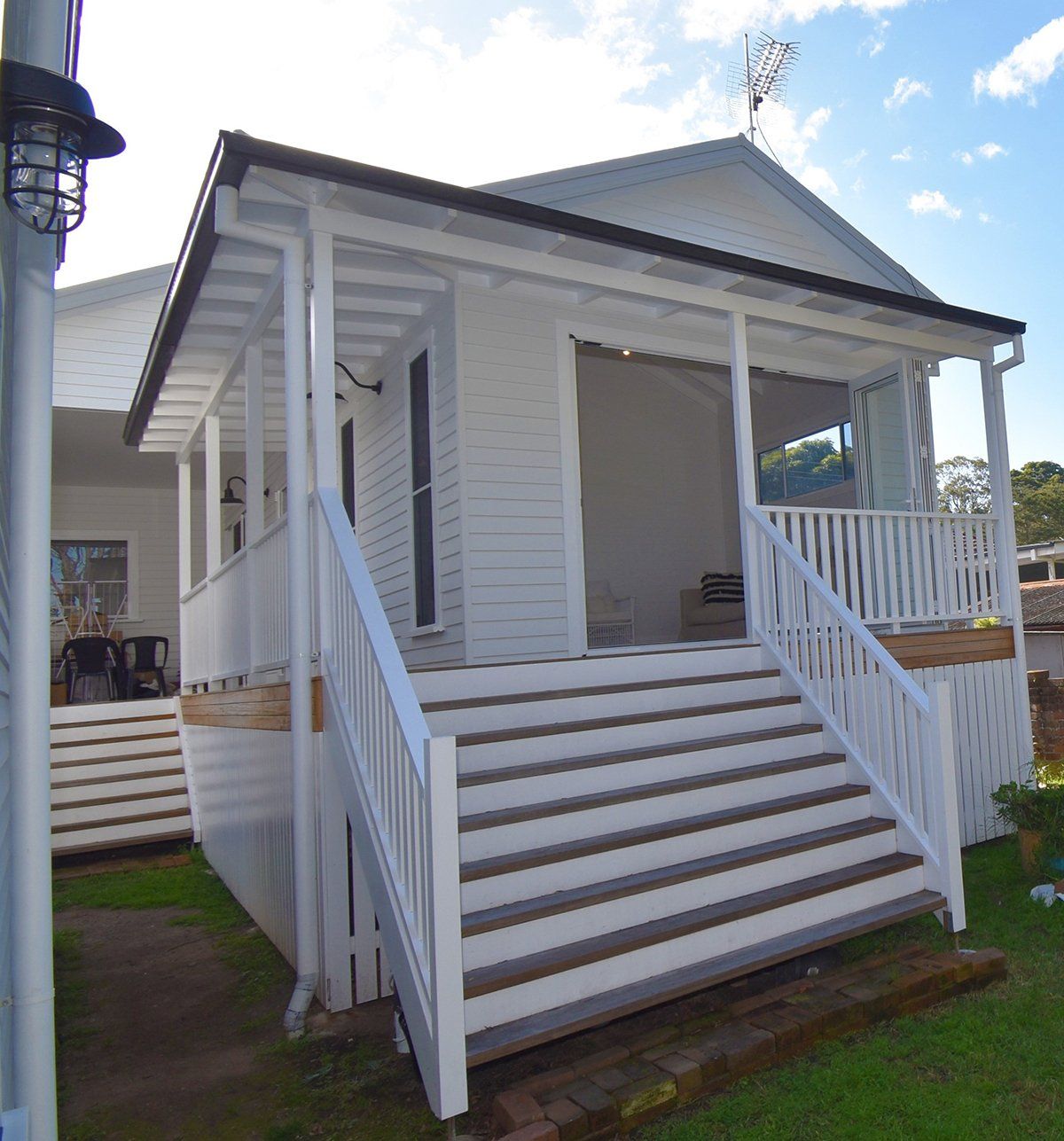 A white house with stairs leading up to the porch