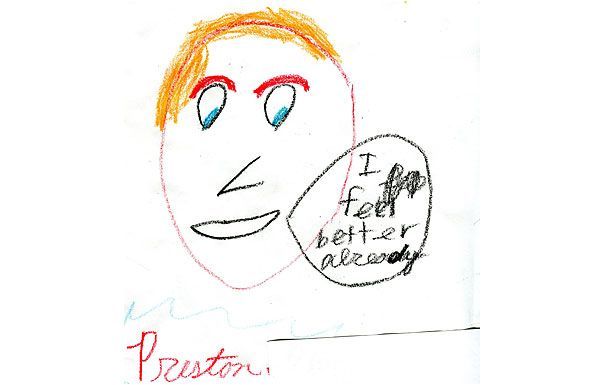 Child's drawing of a face with orange hair and a speech bubble saying 