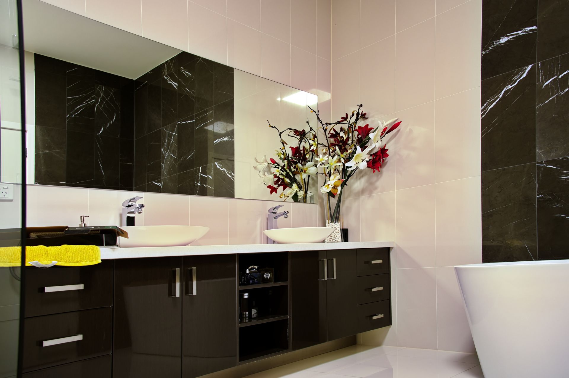 A bathroom with two sinks , a large mirror and a bathtub.