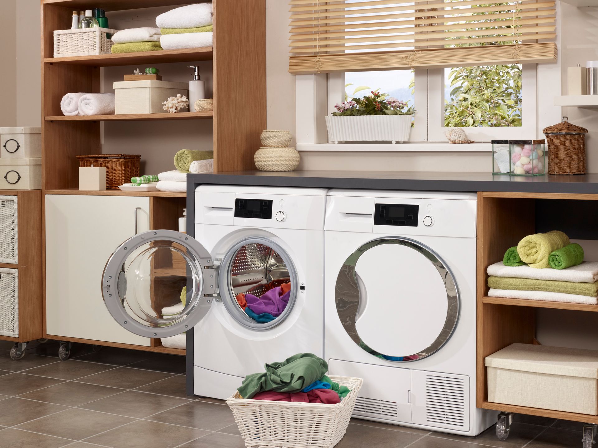 A laundry room with a washer and dryer and a basket of clothes