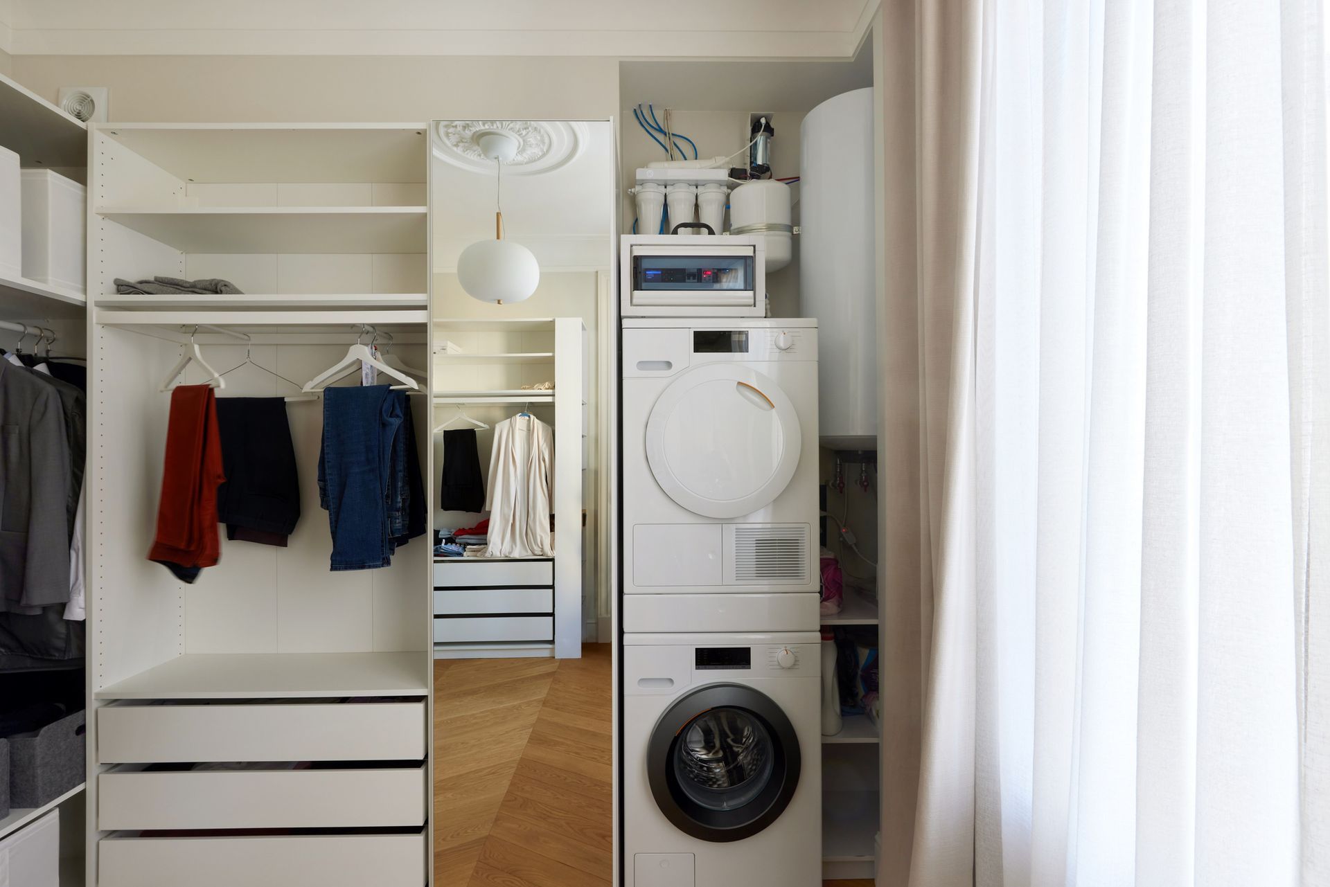 A washer and dryer are stacked on top of each other in a closet.