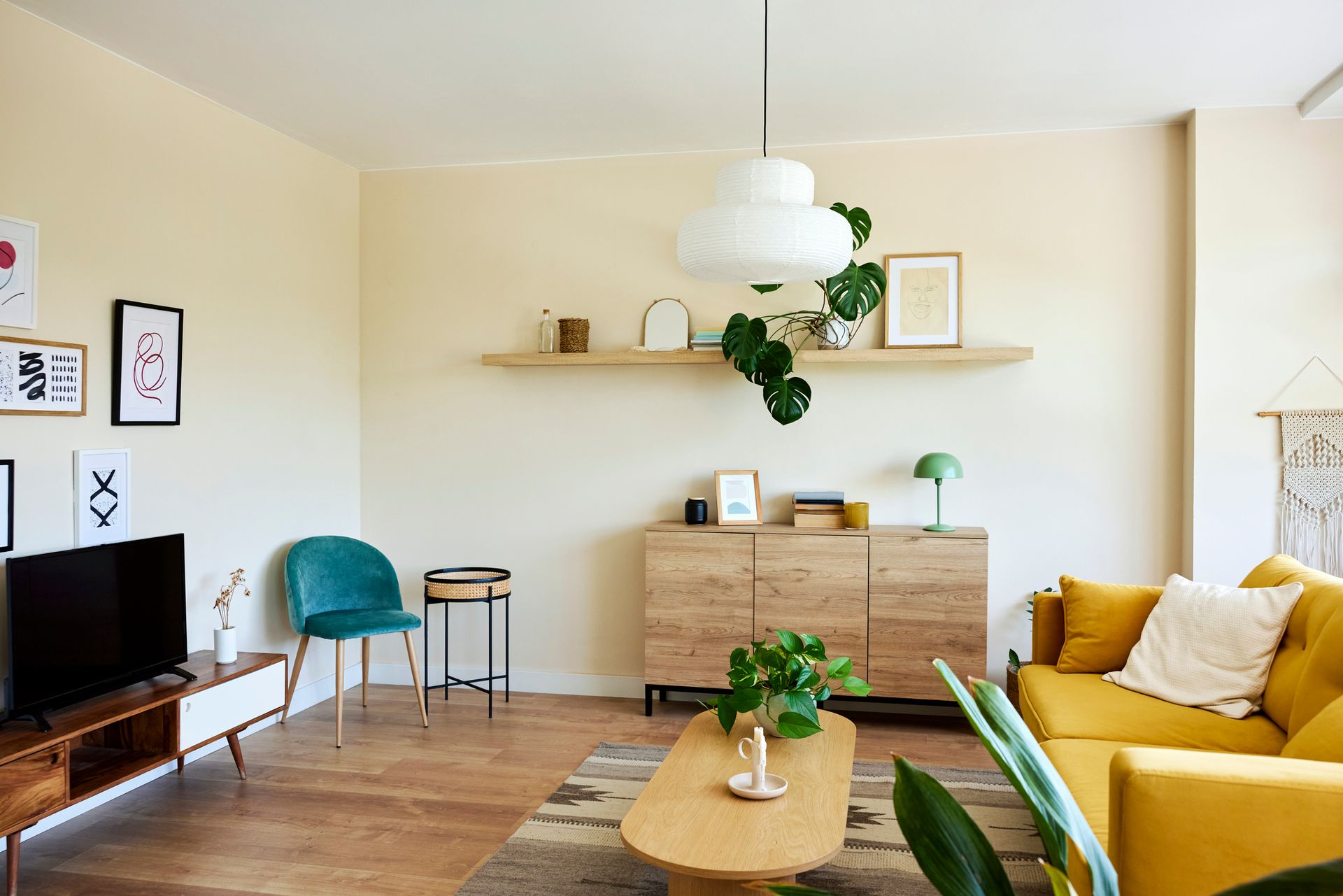 A living room with a yellow couch , coffee table , and television.