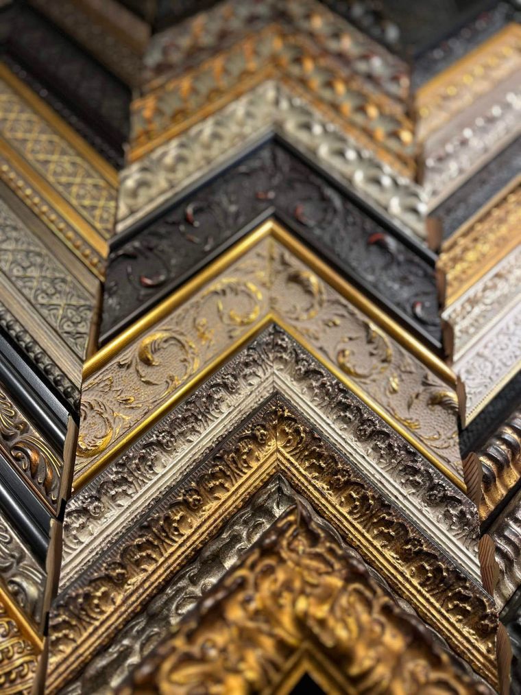 A bunch of different types of picture frames are stacked on top of each other.