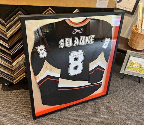 A framed hockey jersey with the number 8 on it.